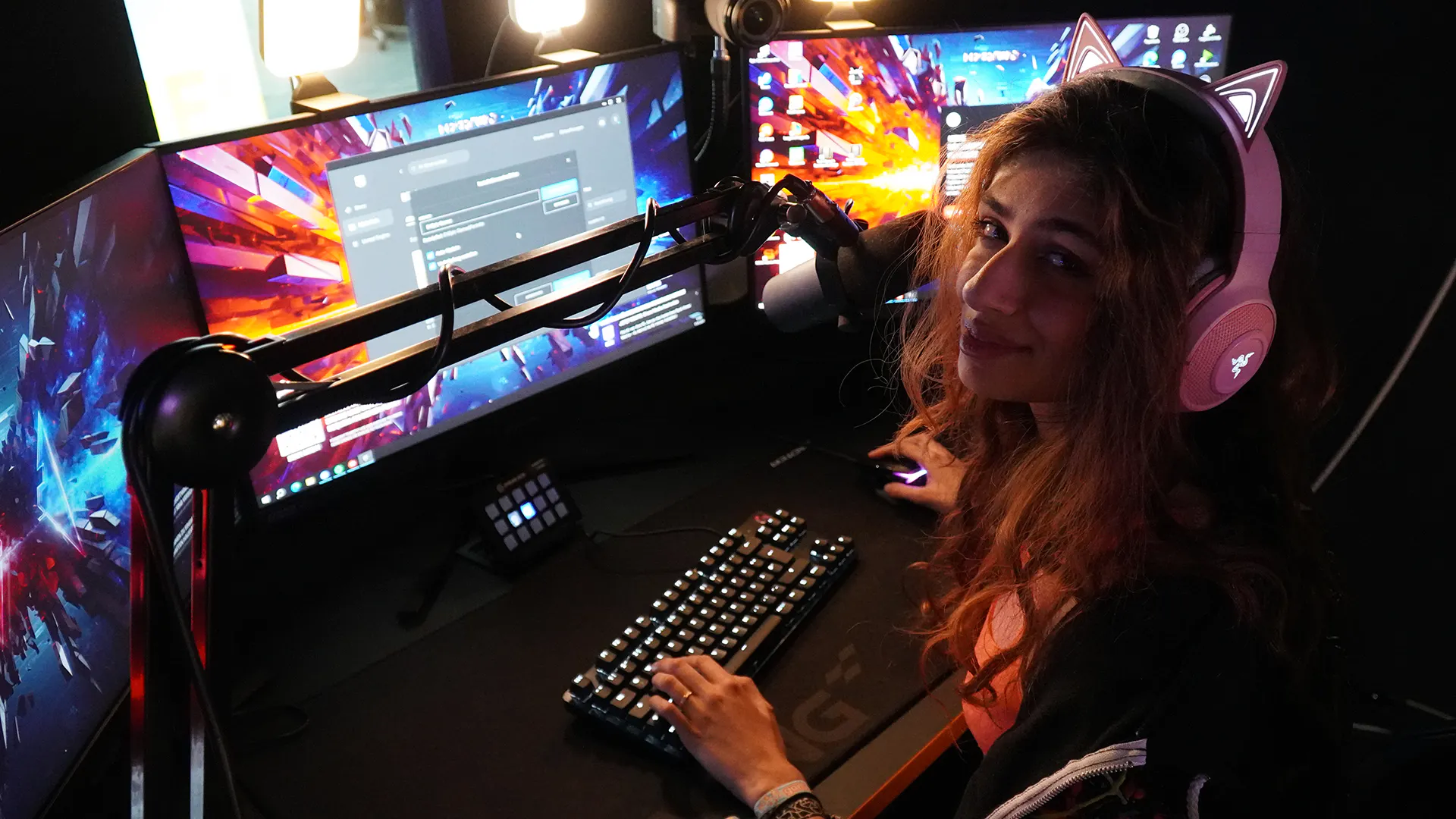 Eine Streamerin an einem Streaming Setup mit LeetDesk schaut in die Kamera