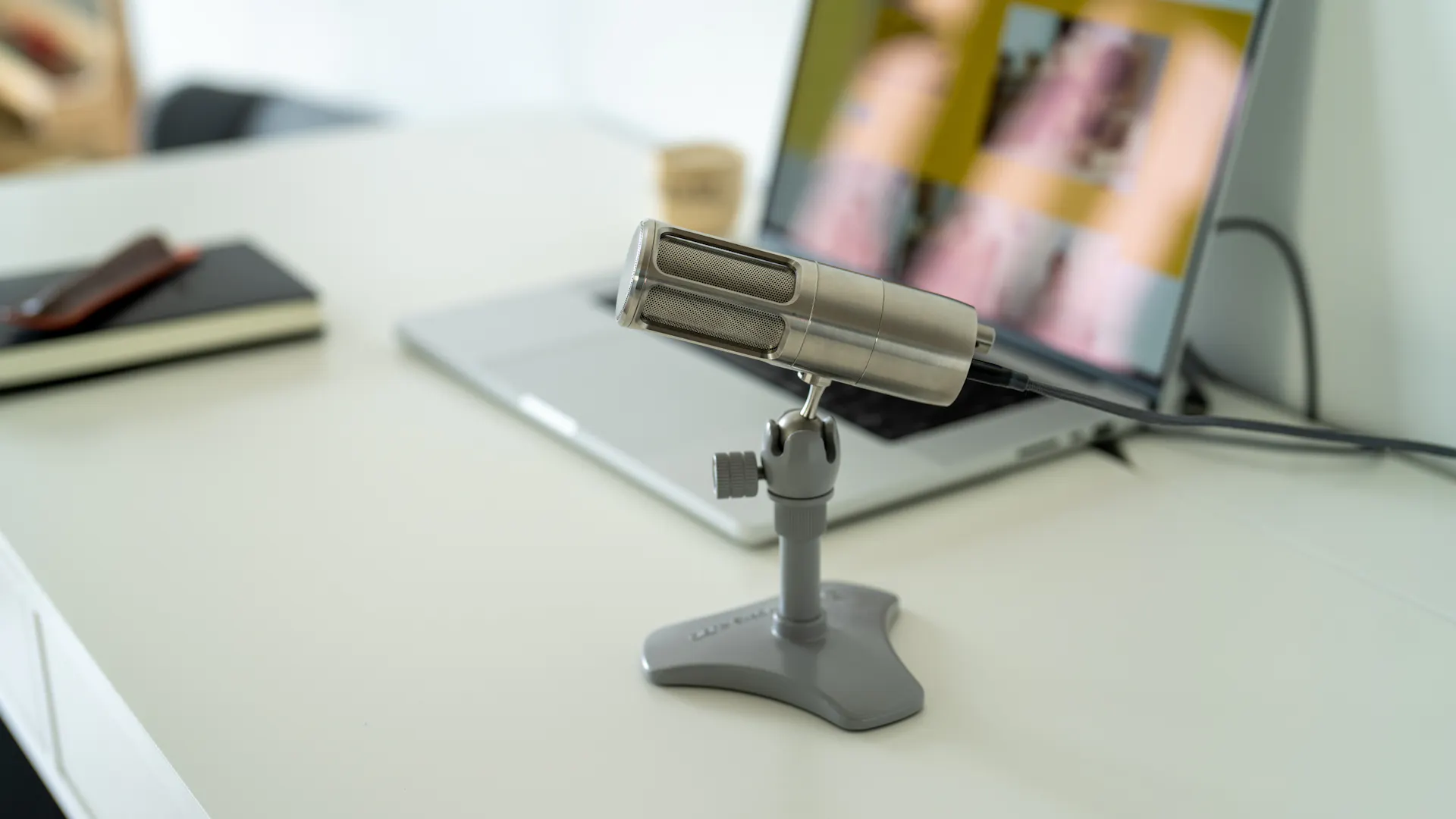 Ein kleines USB Mikrofon das an einen Laptop angeschlossen ist. 