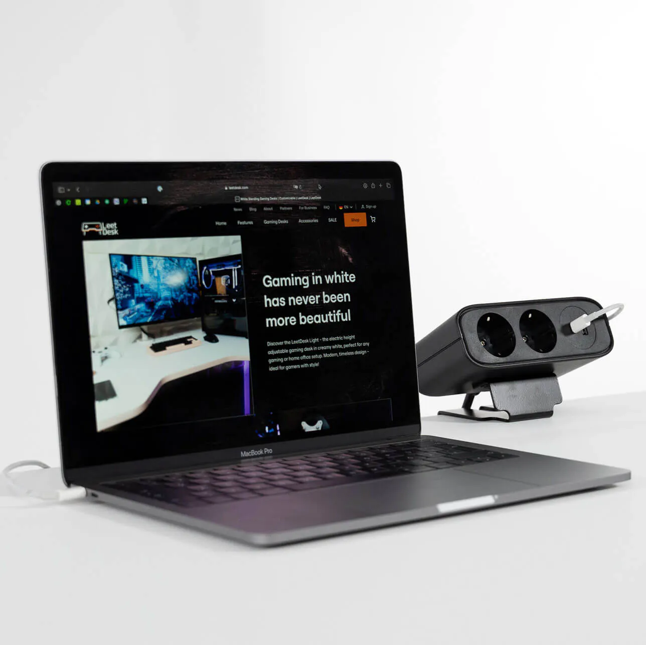 LeetDesk PowerFlak clamp-on socket charging a laptop using a 65W USB-C connection.