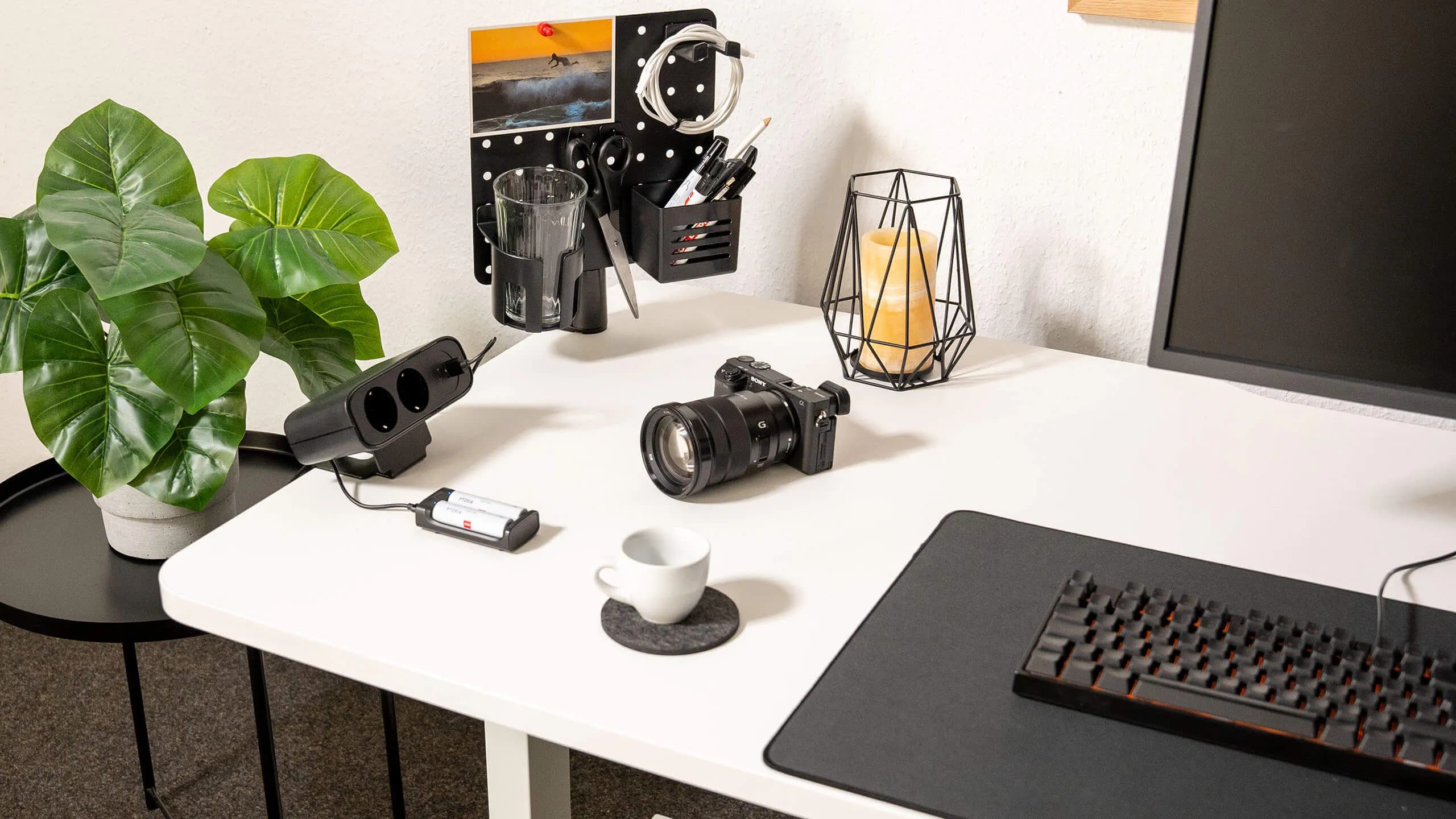 Standing desk setup with LeetDesk PowerFlak clamp-on socket, camera accessories, and desk organizer.