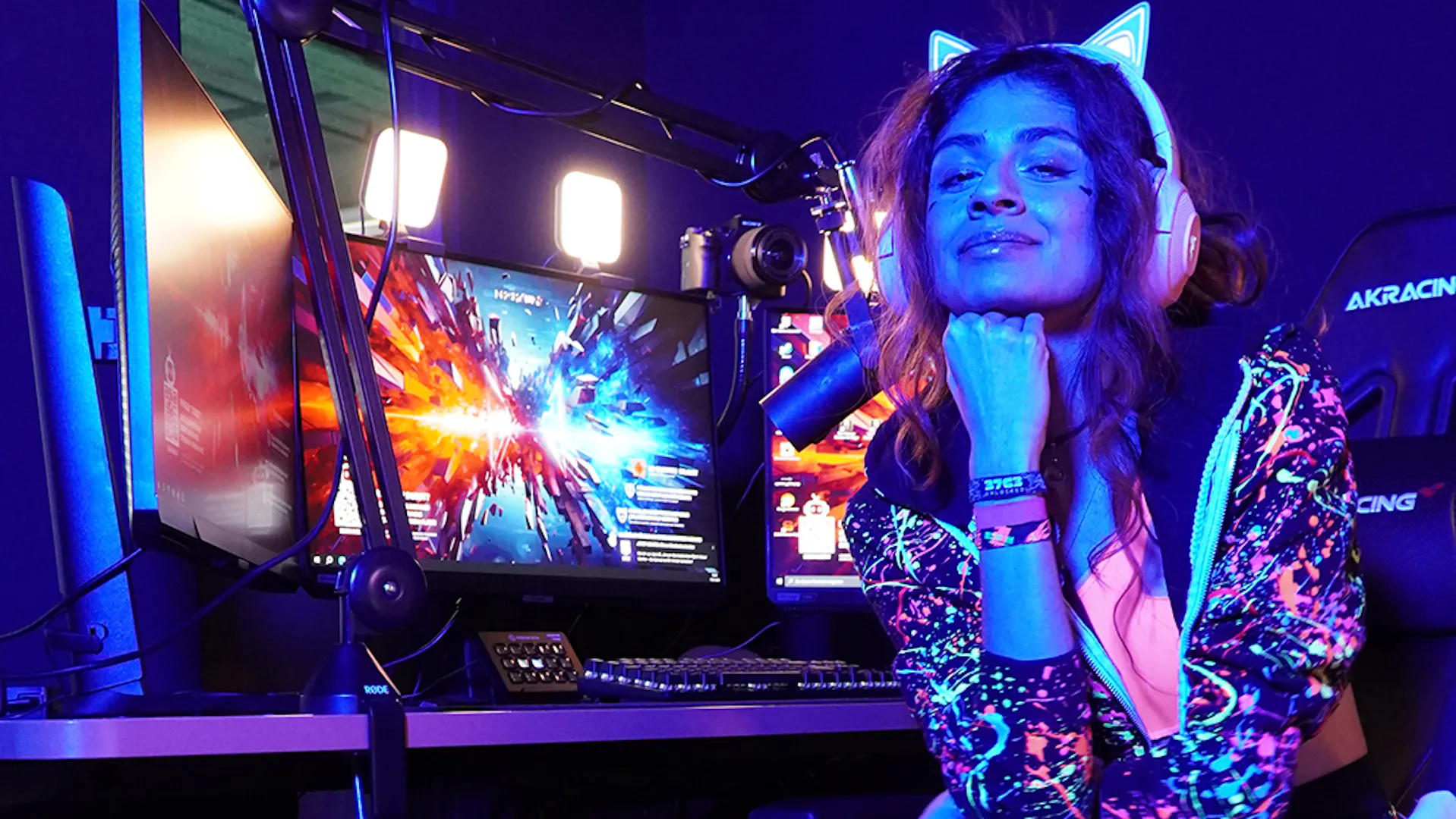 Eine Streamerin schaut in die Kamera während sie an ihrem LeetDesk mit Streaming Setup sitzt